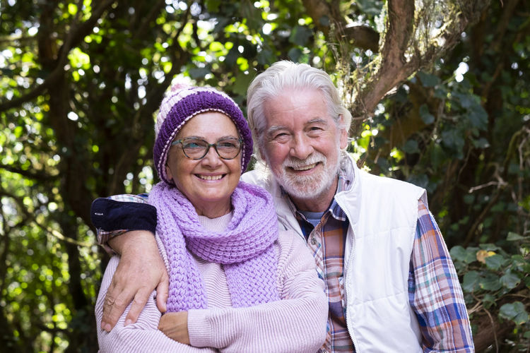 Portrait of smiling senior couple standing at park
