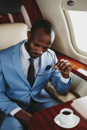 Worried businessman sitting in airplane