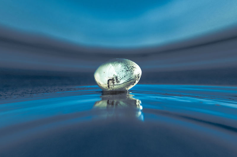 Close-up of water ball in swimming pool against sky