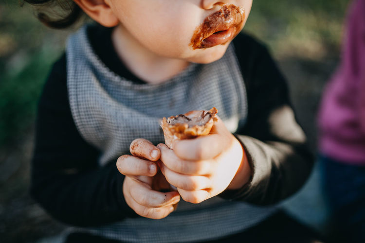 Midsection of child eating chocolate icecream