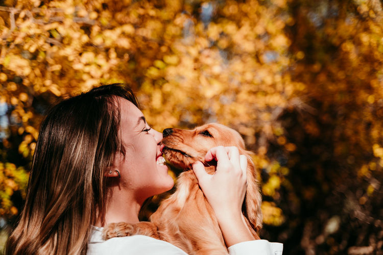 Midsection of woman with dog during autumn