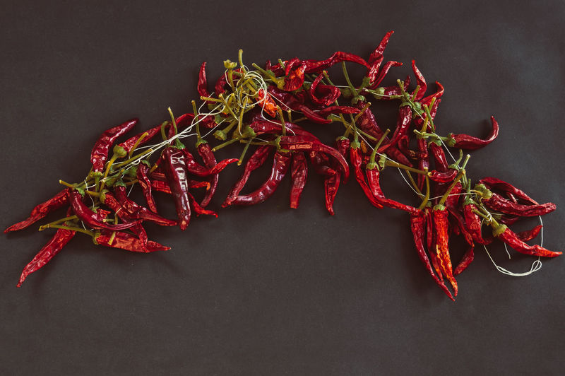 Close-up of red chili peppers on table against black background