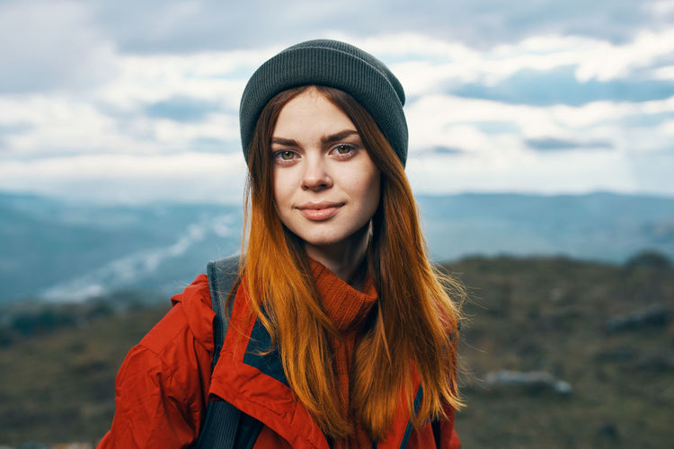 Portrait of young woman standing in park during winter