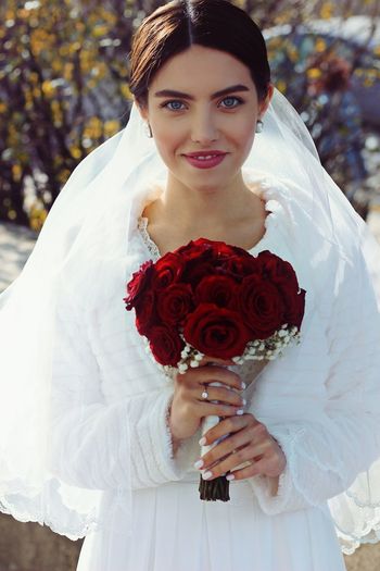 Portrait of smiling bride holding bouquet