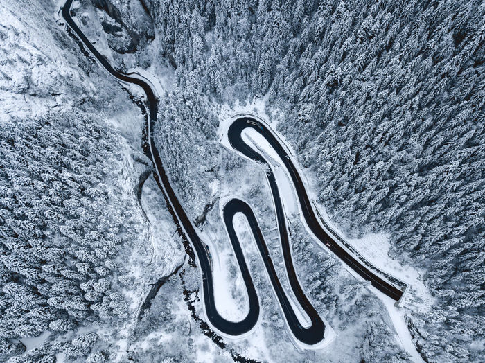 Aerial view of road and forest on snowy landscape