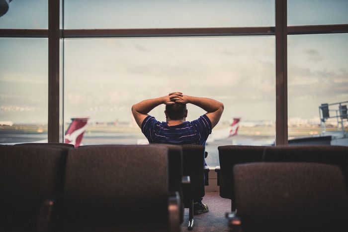 MAN SITTING AT AIRPORT