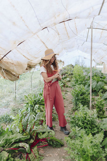 Full length of woman standing amidst plants