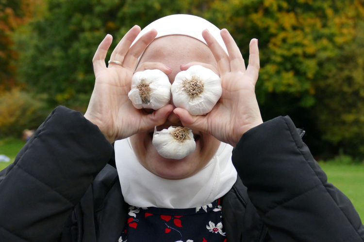 Close-up of woman holding garlic bulbs