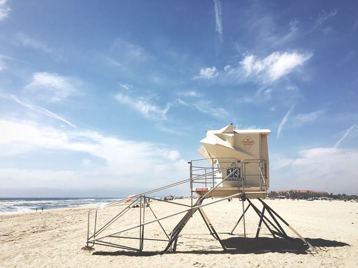 Lifeguard hut at beach against sky on sunny day