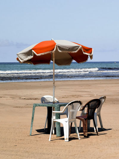 Table with chairs and a parasol on a moroccan beach