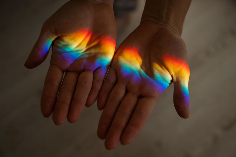 High angle view of rainbow on cropped hands