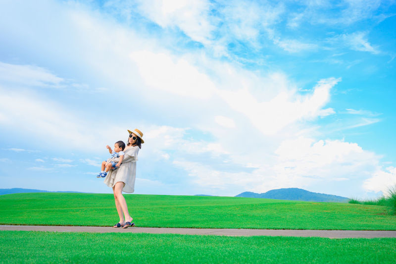 Woman standing on field against sky