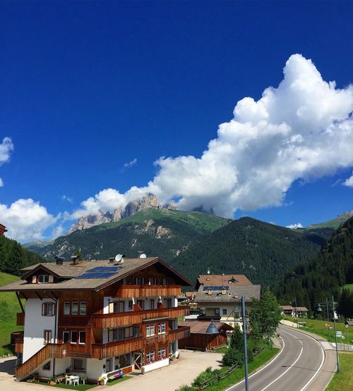 Houses by road against sky at canazei