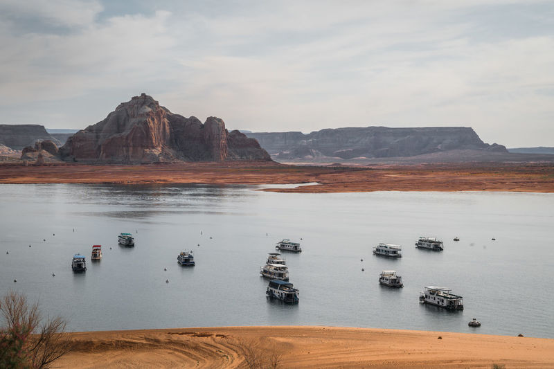 Houseboats on lake powell in warm morning light with nice clouds and reflections. zoomed in shot.
