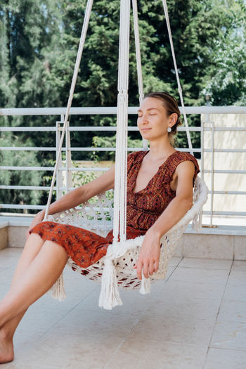 Young woman sitting on swing