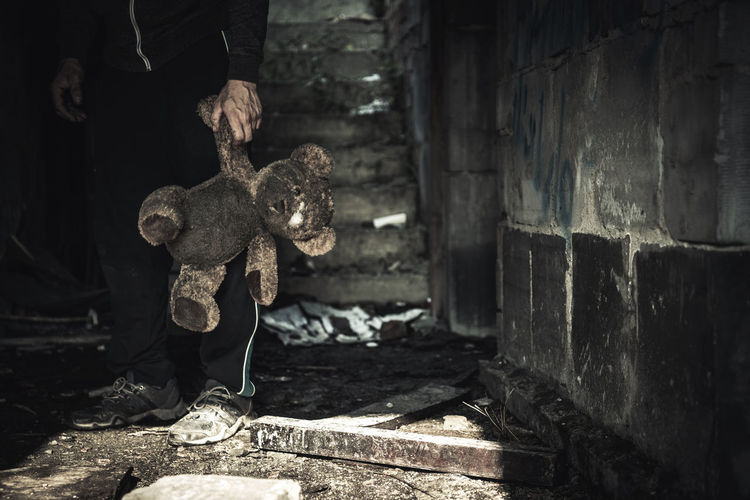 Low section of man holding teddy bear
