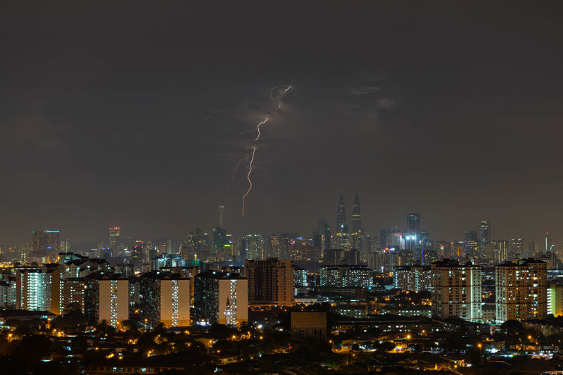 Illuminated cityscape against sky at night
