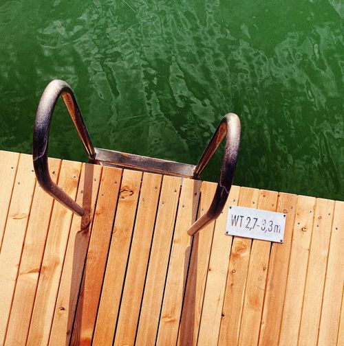 High angle view of text on wooden pier