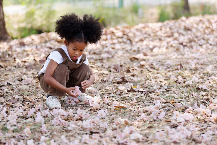Full length of girl playing on leaves