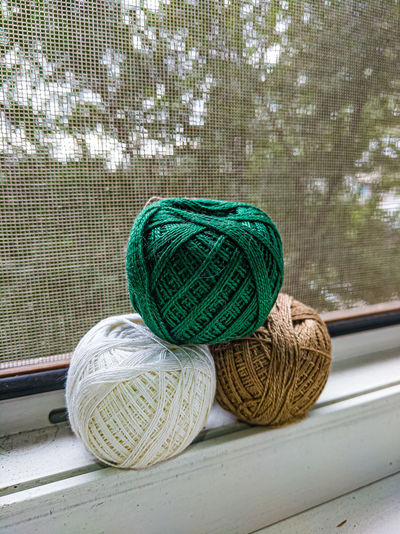 Close-up of woolen balls on window sill