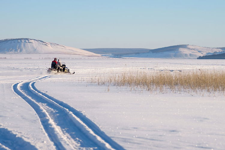 People skiing on snow covered landscape
