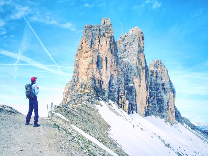 Traveler man enjoying serene view tre cime mountains and landscape. travel lifestyle hiking concept 