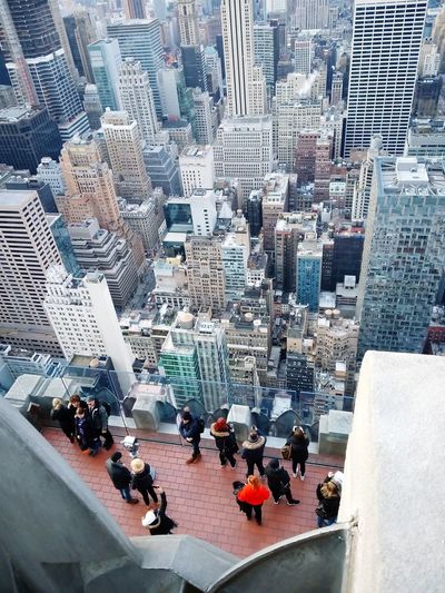 People standing on roof of buildings in city