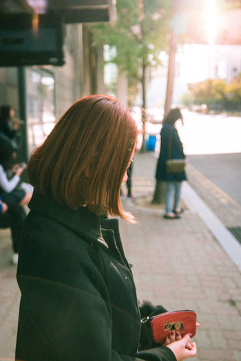 Side view of woman standing outdoors in the city