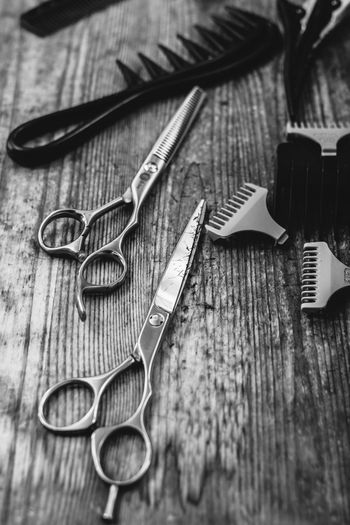 High angle view of scissors and comb on table at barber shop