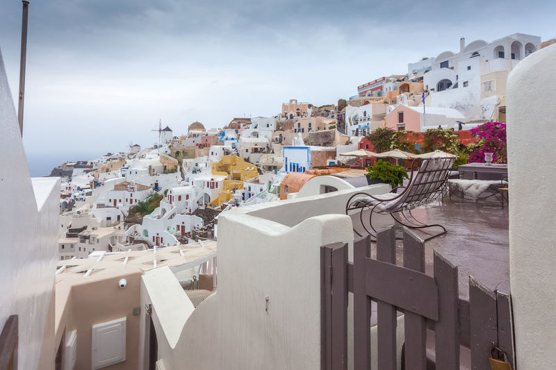 View of colorful houses of oia on a rare rainy day, santorini, greece