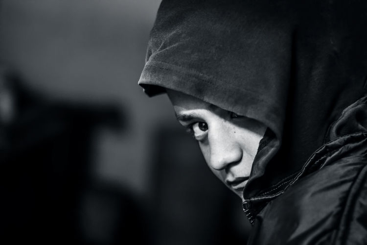 Close-up portrait of teenage boy wearing hooded shirt