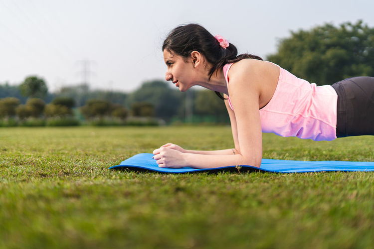 Young woman exercising on field