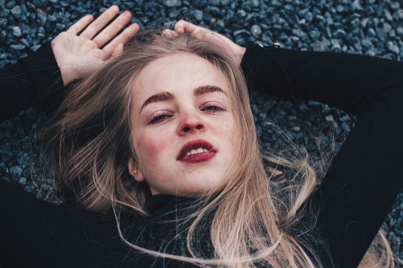Portrait of young woman lying on rocks