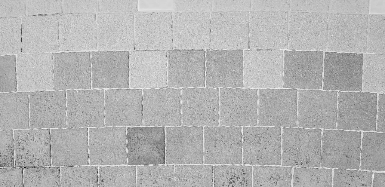 pattern, tile, full frame, backgrounds, flooring, wall - building feature, built structure, architecture, floor, no people, textured, wall, tiled floor, day, geometric shape, shape, road surface, brick, building exterior, gray, stone material, outdoors, close-up, repetition, black and white