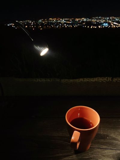 Illuminated tea light on table at night