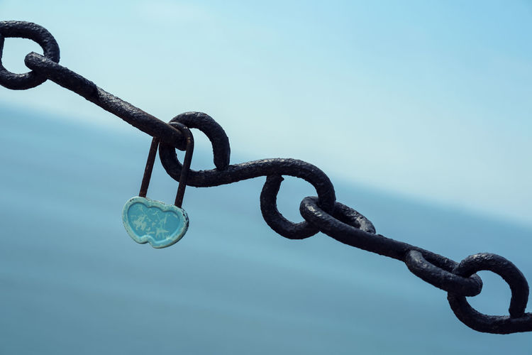 Close-up of chain against blue sky