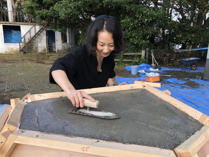 Woman plastering concrete outdoors