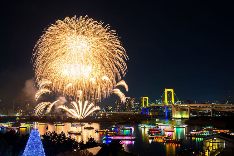 Firework display over river at night