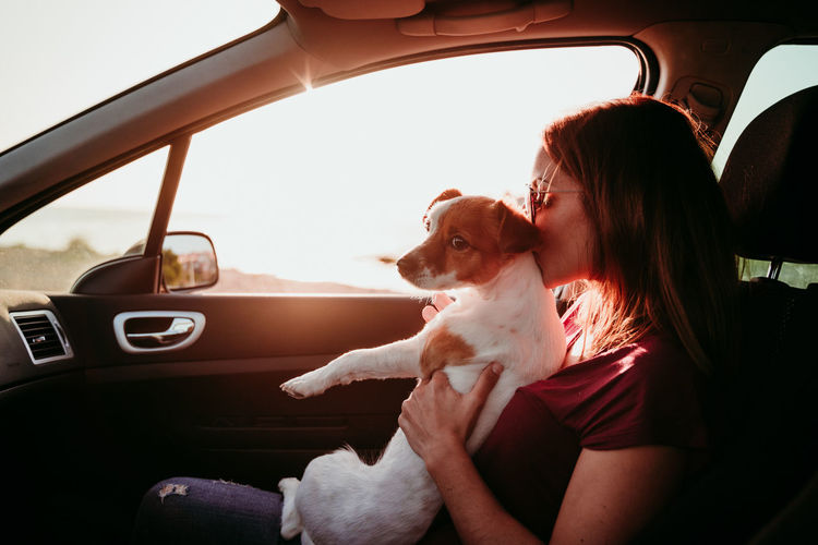Woman sitting with dog in car