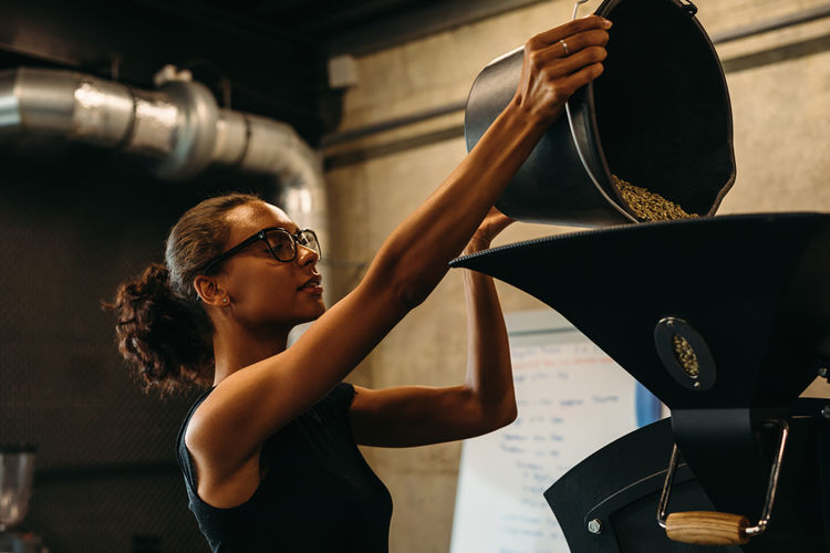 Side view of young barista working in cafe