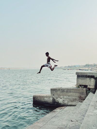 Side view of man jumping in sea