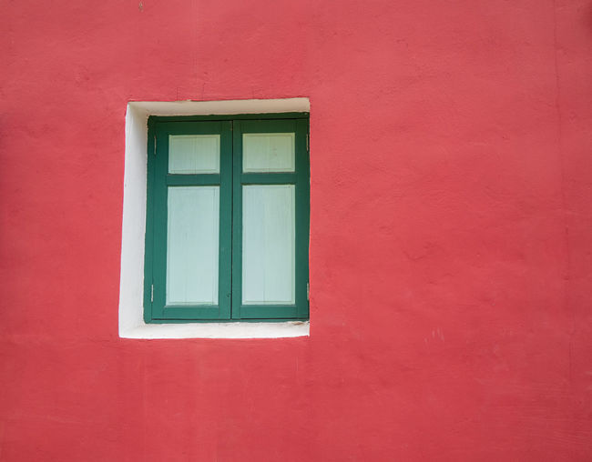 Close-up of window on red wall