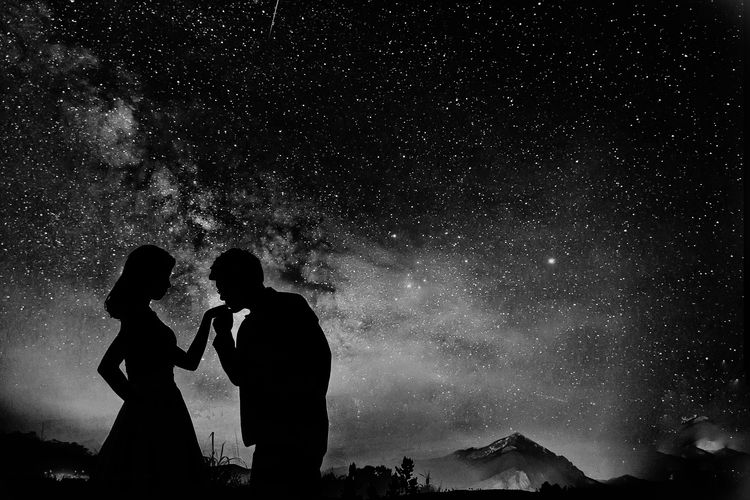 Silhouette couple against sky at night
