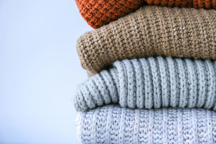 Stack of cozy knitted warm sweater. sweaters in retro style. orange and blue colors. cozy hygge 