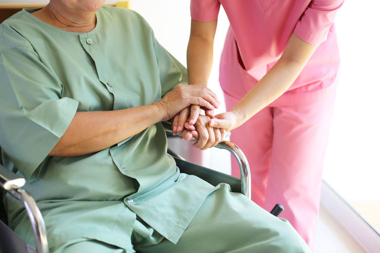 Midsection of doctor examining patient in hospital