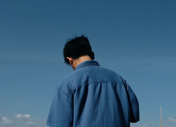 Rear view of man against clear blue sky