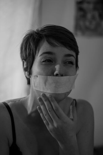 Crying woman with duct tape on mouth
