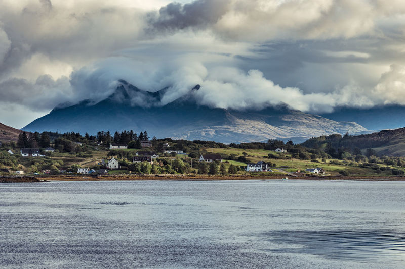 Scenic view of sea and mountains against sky