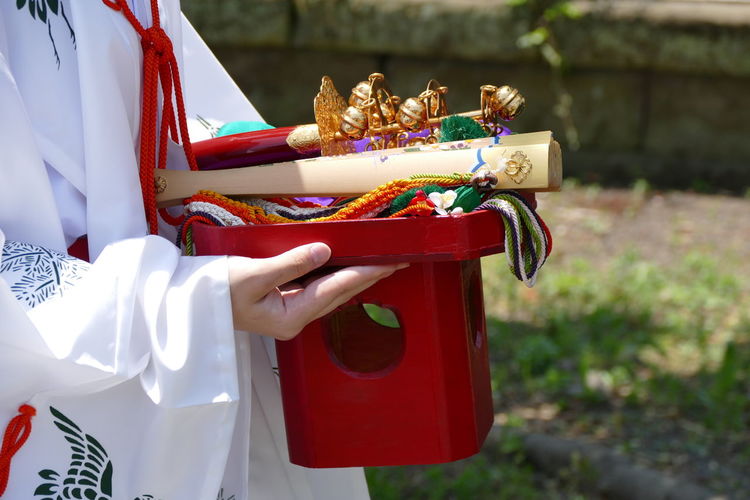 Side view of person holding religious objects in hand