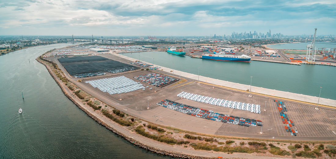 Aerial panorama of port melbourne with  imported cars parking lots, and melbourne cbd skyline 